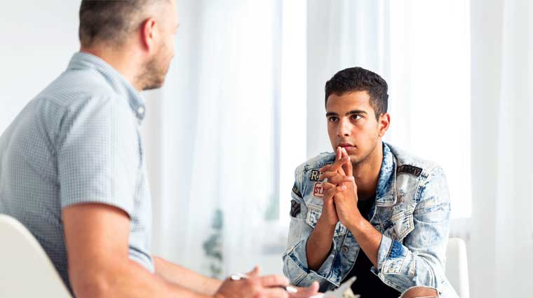 counselor talking to teen boy